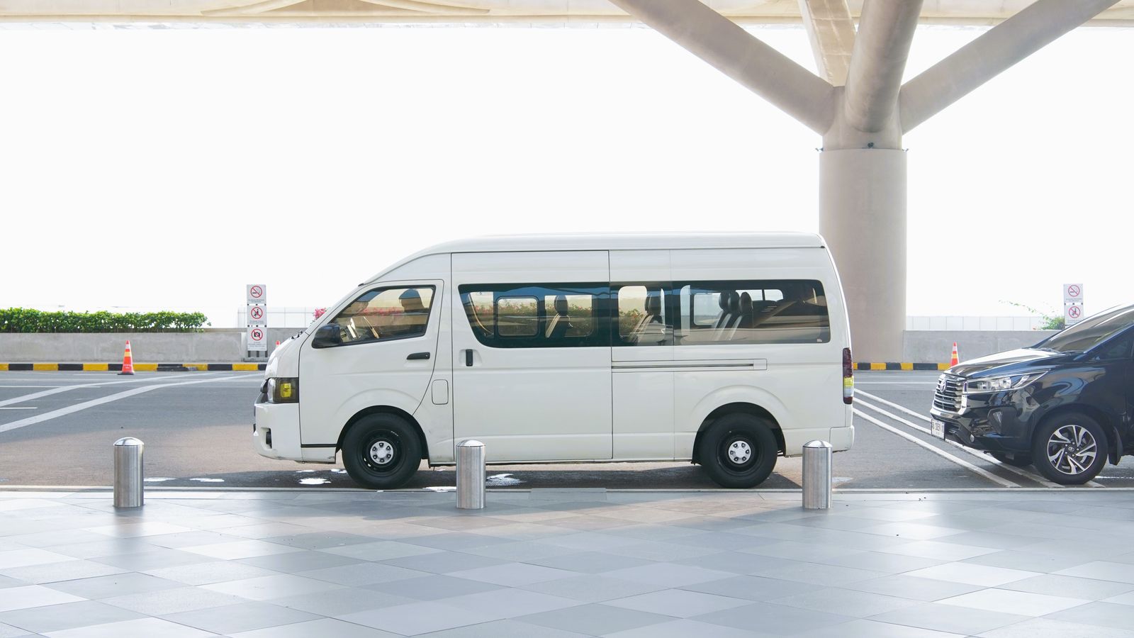 Van parked at a modern airport terminal curb