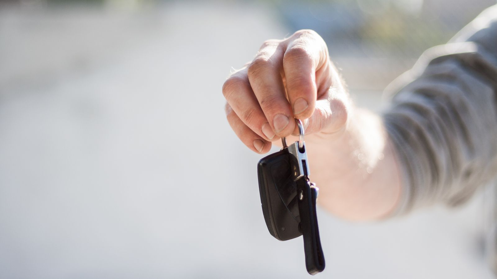 Hand holding out car keys