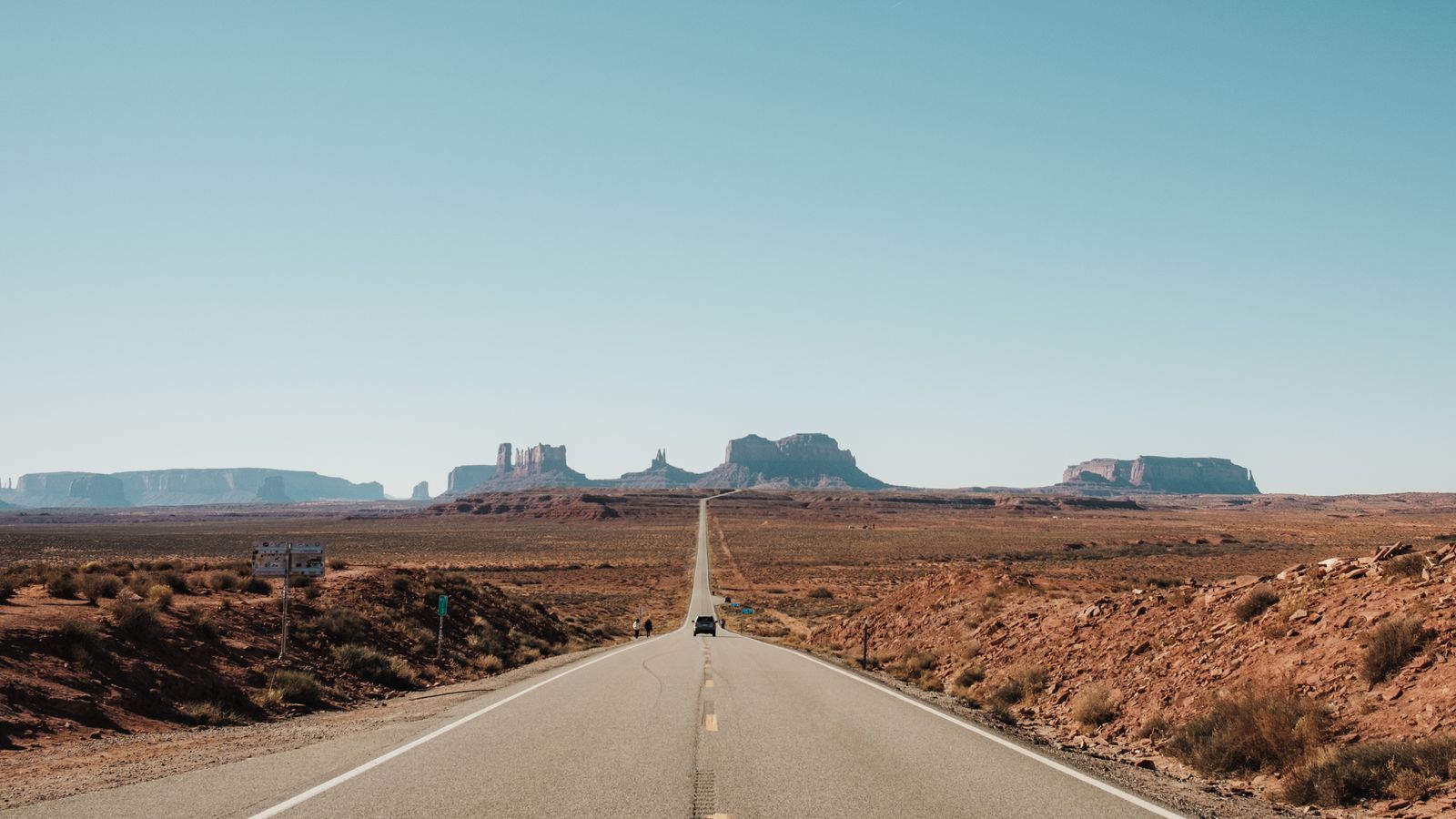 Straight road leading toward the buttes of Monument Valley